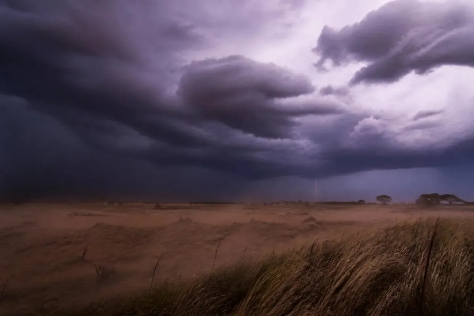 A dramatic sky filled with churning purple clouds, capturing a brewing storm.